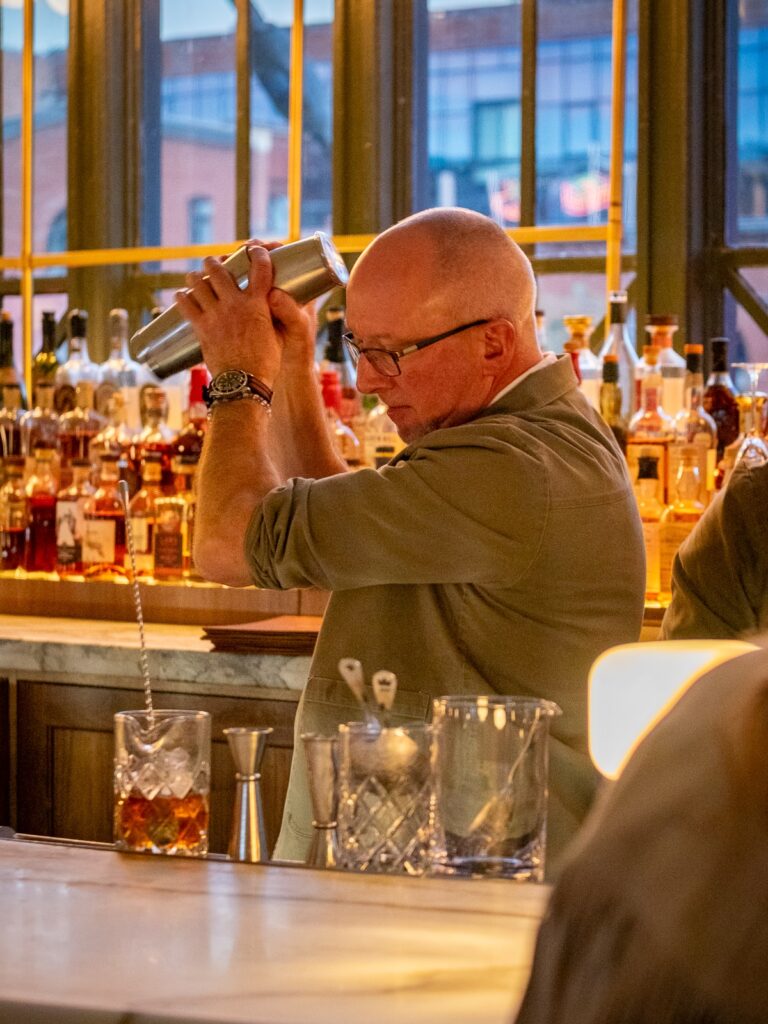 Bartender making drinks at Cooper Lounge bar at Denver's Union Station